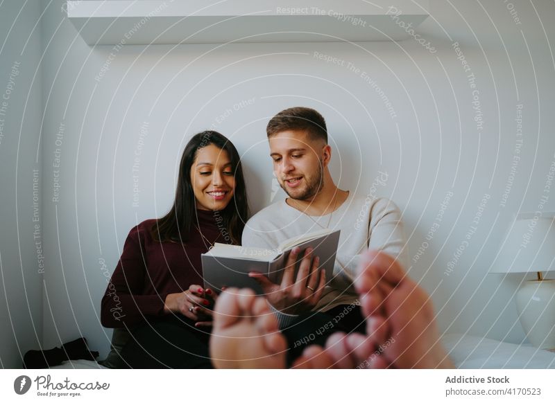 Couple resting on bed at home couple barefoot bedroom domestic relax chill carefree weekend girlfriend boyfriend cheerful happy comfort young sit cozy romantic