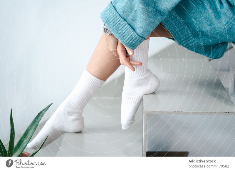 Woman in white socks at home cozy domestic outfit woman sweater grace tender stair female warm bright house rest style sit step trendy serene lady slim slender