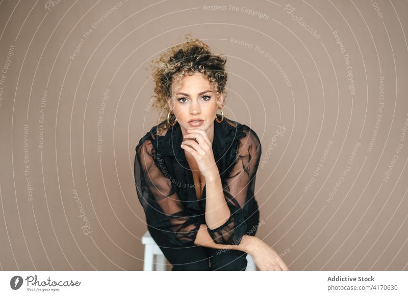 Thoughtful woman in black outfit in studio elegant pensive lean on hand charming appearance thoughtful female serious trendy fashion modern confident gorgeous