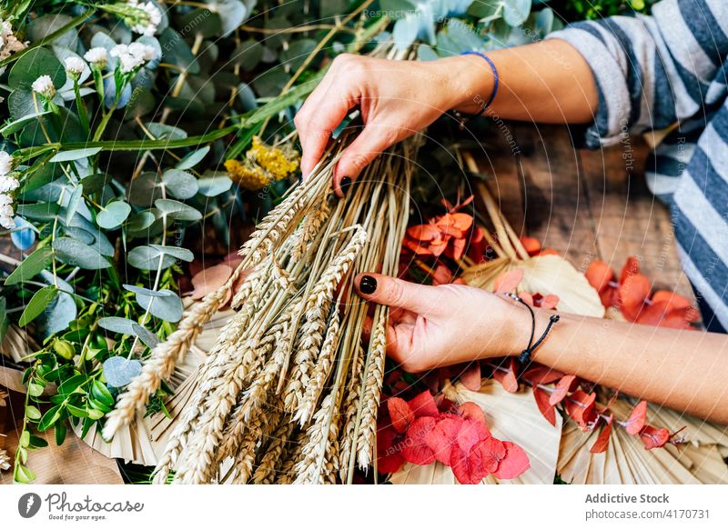 Anonymous woman with flower bouquet in shop store florist bloom celebration ornaments design decoration horizontal spruce female wooden table compose arrange