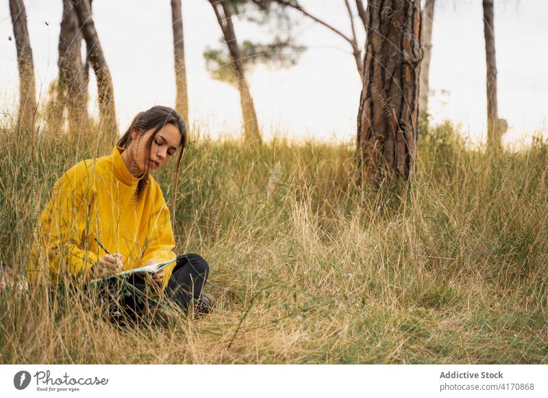 Woman taking notes in notebook in nature take note woman diary write relax thoughtful reflect peaceful female meadow dry calm countryside weekend tranquil