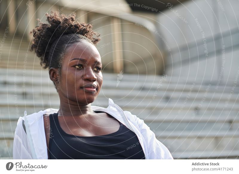 Black sportswoman relaxing on stairs in city workout break athlete confident sportswear runner female ethnic black african american stone street rest sit