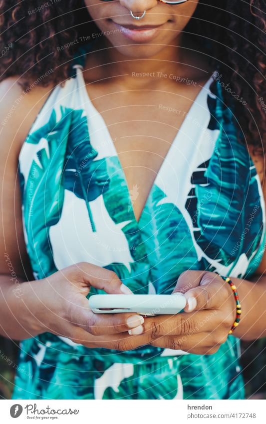 African girl's close-up using her smartphone woman african communication technology cellphone telephone mobile afro smart phone ethnicity mobile phone