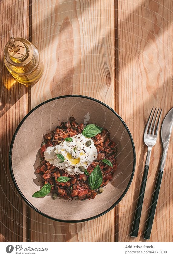 Eggplant Ragout served on bowl on table hard light natural product ricotta ingredient white tasty burrata cheese leaf specialty italy creamy green fresh