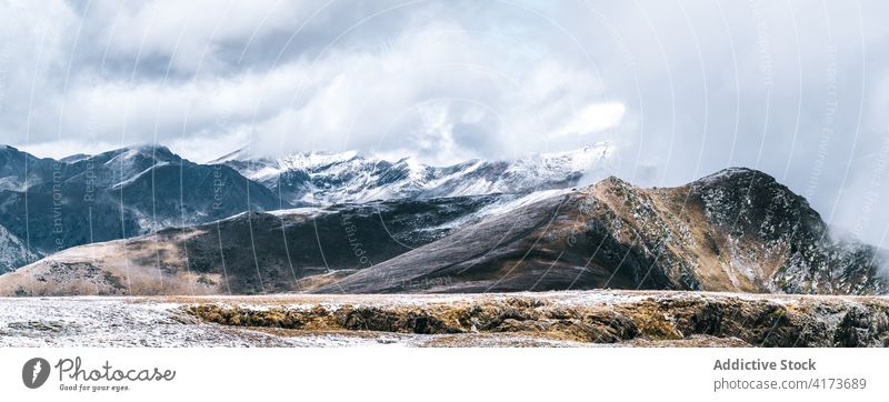 Rocky mountain ridge covered with snow rock range rough slope peak cloud panorama cold majestic scenery rocky nature landscape altitude environment picturesque