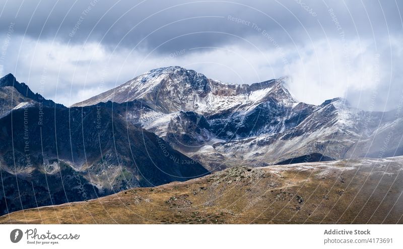 Rocky mountain ridge covered with snow rock range rough slope peak cloud panorama cold majestic scenery rocky nature landscape altitude environment picturesque