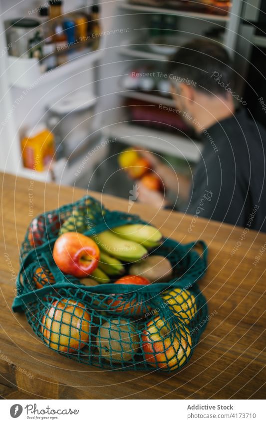 Sack with fresh fruits on table in kitchen sack eco friendly bag zero waste ecology cotton person ripe vegetarian natural vitamin healthy food banana apple