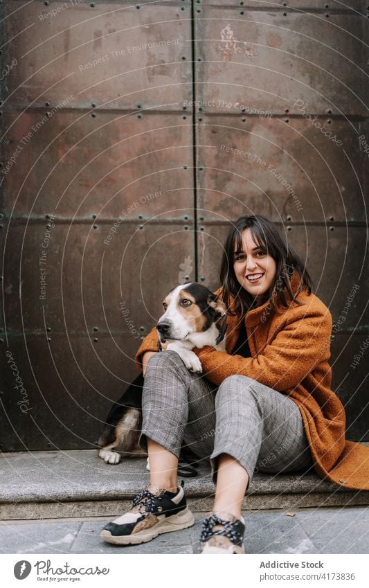 Tender woman hugging dog in city tender owner together friendship treeing walker coonhound street female pet animal canine embrace affection domestic sit love