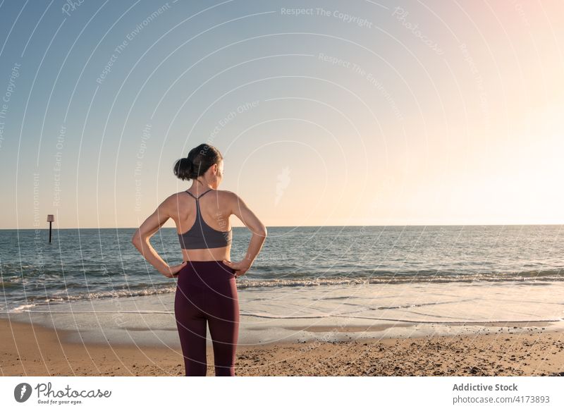 Fit woman in sportswear resting on beach fit sporty sea slim shore fitness workout female sunny coast ocean relax sand lifestyle wellness healthy wellbeing