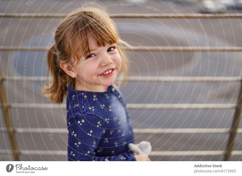 Happy little girl playing on street happy cheerful kid summer having fun enjoy child adorable childhood content positive smile cute lifestyle playful innocent