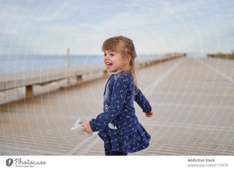 Happy little girl playing on street happy cheerful kid summer having fun enjoy child adorable childhood content positive smile cute lifestyle playful innocent