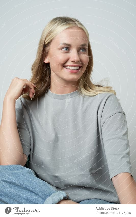 Delighted woman laughing in studio casual style natural beauty female cheerful positive delight glad happy young lady legs crossed carefree content enjoy