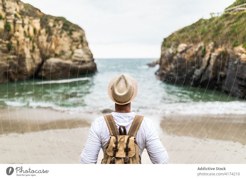 Happy male traveler enjoying vacation at seaside freedom carefree man arms raised summer coast shore beach nature holiday ocean sand stand tourist harmony