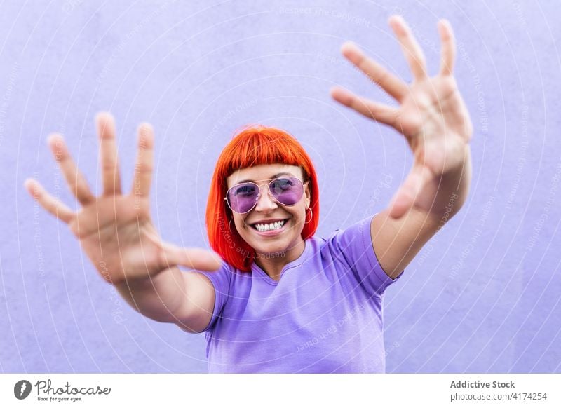 Happy stylish woman showing hands rebel subculture style street outstretch smile happy colorful bright female adult demonstrate redhead ginger dyed hair