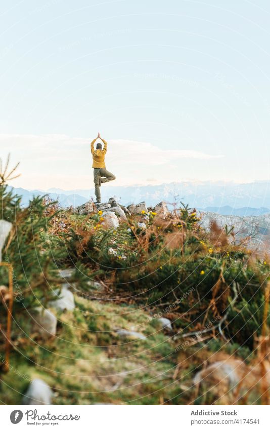 Traveler doing yoga in Tree pose in mountains tree pose traveler meditate balance zen highland sunset explorer trekking adventure harmony nature concentrate