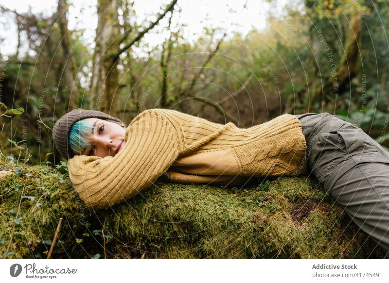 Tired traveling woman relaxing on tree trunk in woods forest trekking tired hiker lying explorer female break recreation nature adventure tranquil moss enjoy