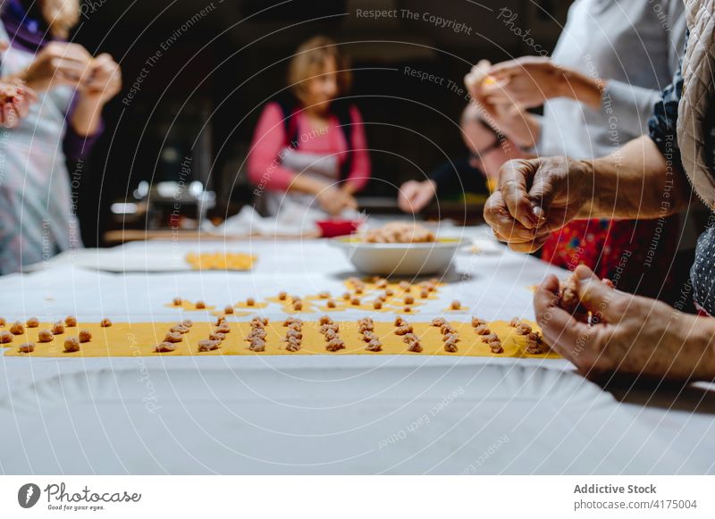 Crop women cooking traditional tortellini in kitchen prepare dumpling italian food homemade ingredient meat dough raw italian cuisine table recipe meal process