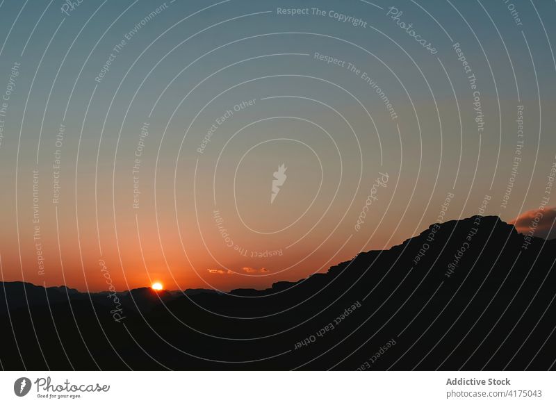 Bright sunset over silhouette of mountains sky orange twilight landscape highland scenery wadi rum jordan rocky terrain evening sundown amazing dusk peaceful