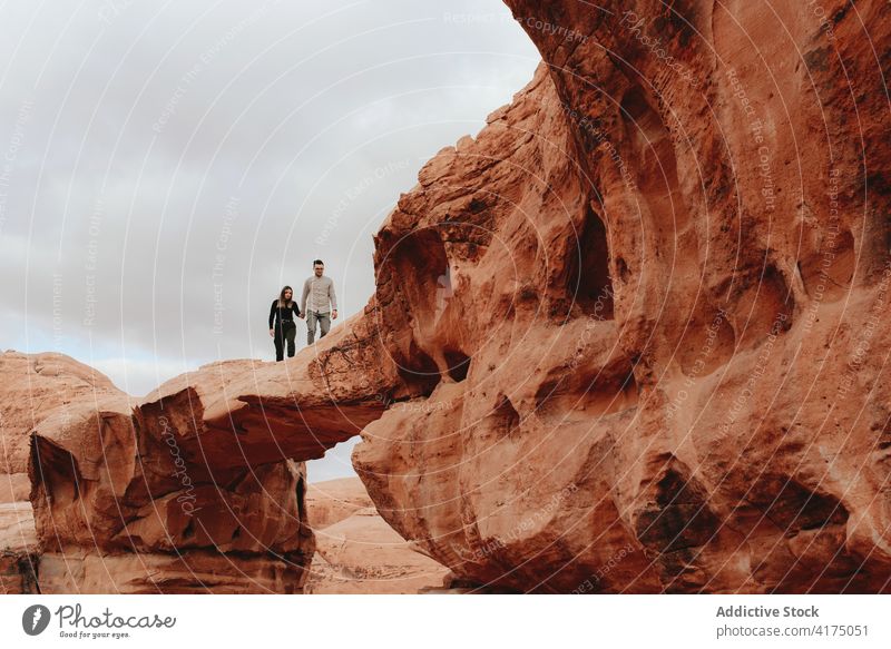 Couple on top of rock in desert couple terrain dry vacation traveler together valley relationship wadi rum jordan journey tourism stone nature trip freedom