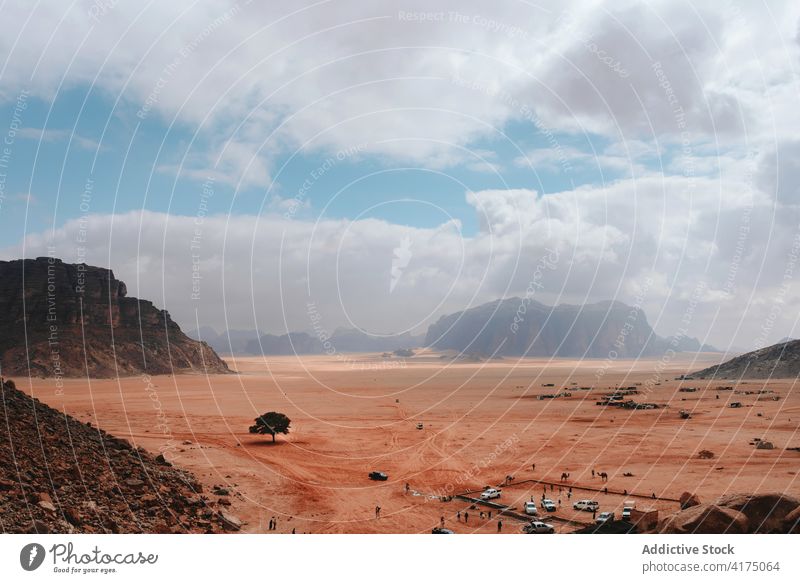 Wadi Rum on background of camp with cars in scenic view rock terrain sandstone valley dry rough wadi rum jordan nature tourism wanderlust adventure picturesque