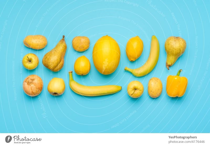 Yellow fruits and vegetables isolated on a blue background. above aligned apple banana bright citrus collection colorful colors copy space creative cut out