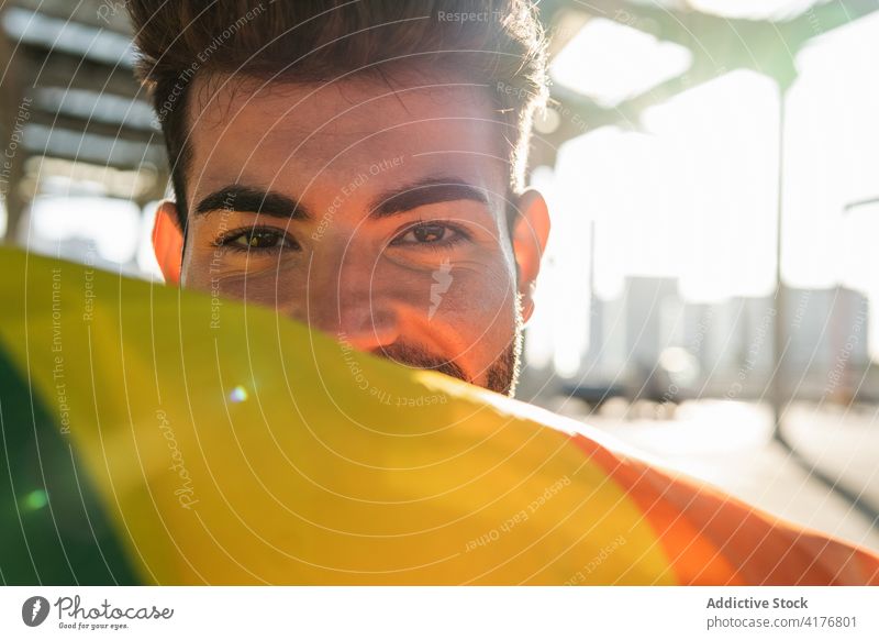 Homosexual man with LGBT flag rainbow homosexual lgbt gay street excited smile positive male lgbtq tolerance city pride right cheerful equal freedom gender