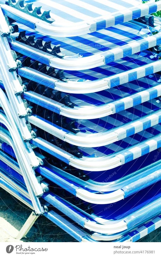 Detail of a stack of blue and white sunbeds in the glaring sunlight vacation Sun Summer sun lounger Stack Blue White Bright Greece detail Glittering Steel Metal