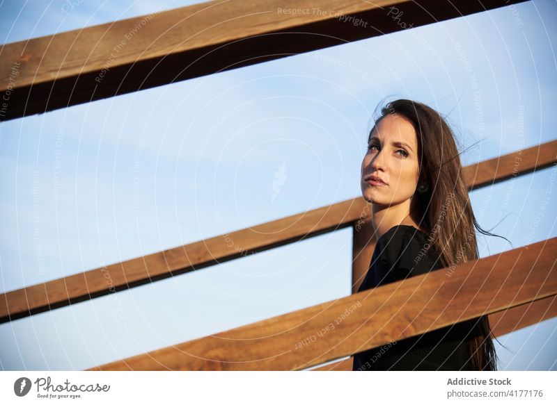 Tender woman on boardwalk on beach sweater fence promenade calm serene alone beautiful recreation lean on casual rest tranquil style charming leisure female