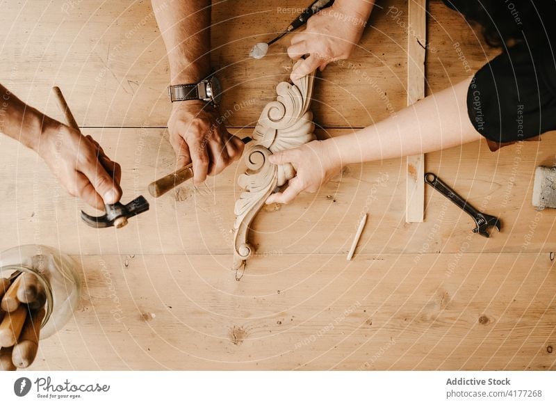 Carpenters creating wooden detail with chisel carpenter hammer carve woodwork instrument workshop artisan tool carpentry professional together hand cowork