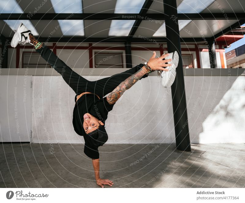 Male break dancer performing handstand man trick acrobatic energy move style active young male activity lifestyle skill modern practice balance talent agile