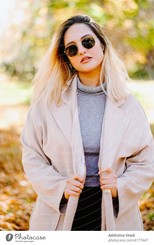 Young woman in coat in autumn park outfit smile stroll weekend casual young female cheerful happy optimist delight trendy pleasant glad positive lady stand