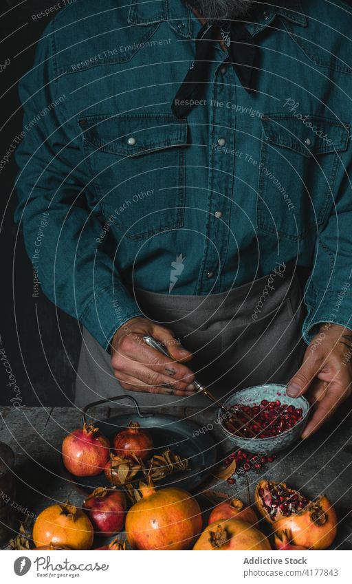 Crop person peeling ripe pomegranate in kitchen fork fruit delicious pile harvest rustic table fresh food tasty healthy meal yummy organic cook cuisine culinary