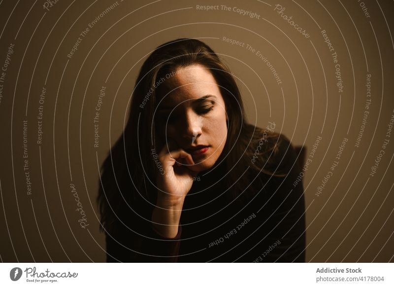 Sad woman in black clothes in studio sad pensive thoughtful think unhappy lonely upset problem ponder frustrate stress female young trouble melancholy