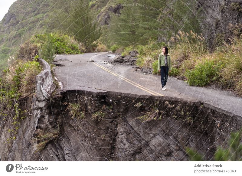 Woman standing on road on rocky coastline traveler sea ocean edge destroy shore woman nature seashore asphalt seaside wave broken stormy waterfront female rough