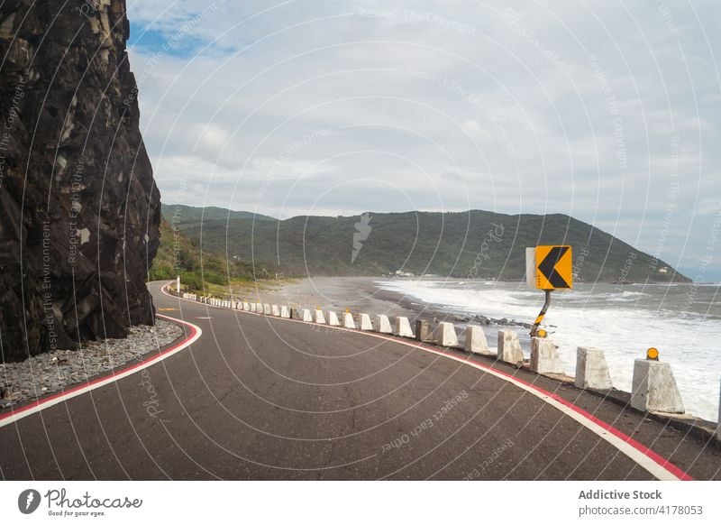 Asphalt road along sea in mountainous area roadway scenery amazing picturesque empty asphalt sunny east coast route direction destination location season