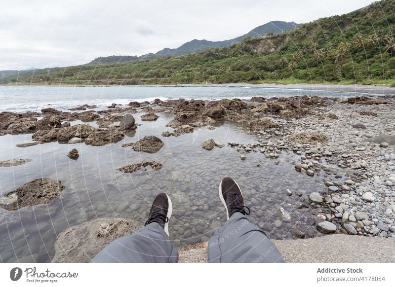 Crop traveler at seaside in summer leg seascape explorer vacation rock beach seashore mountain east coast nature holiday landscape majestic tourism relax scenic