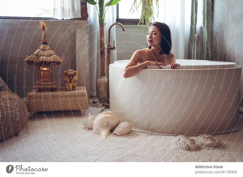 Ethnic woman resting in bathtub in oriental style room interior design tradition relax hotel young asian ethnic female travel tourism enjoy vacation chill