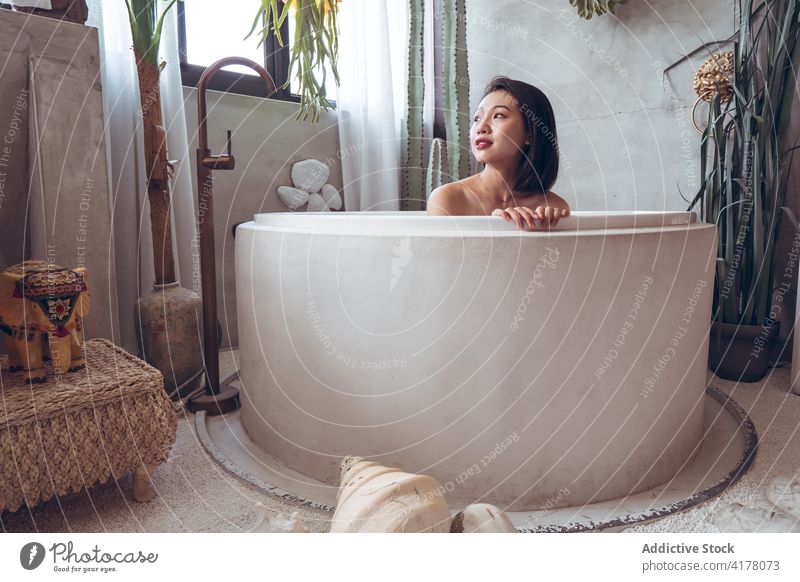 Ethnic woman resting in bathtub in oriental style room interior design tradition relax hotel young asian ethnic female travel tourism enjoy vacation chill