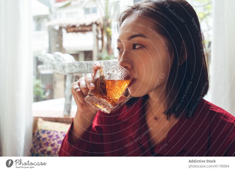 Ethnic woman having breakfast in hotel with oriental interior design tea drink relax tradition table young asian female ethnic travel tourism taiwan cozy