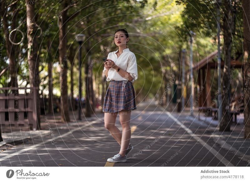 Asian woman walking along bicycle path bikeway lane smartphone browsing city message female ethnic asian tanya shen green bikeway taichung taiwan gadget mobile