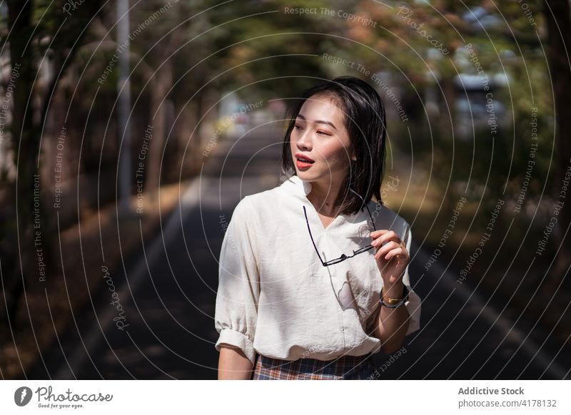 Stylish woman standing on alley in city park bicycle lane sunny stroll enjoy carefree path summer female asian ethnic tanya shen green bikeway taichung taiwan