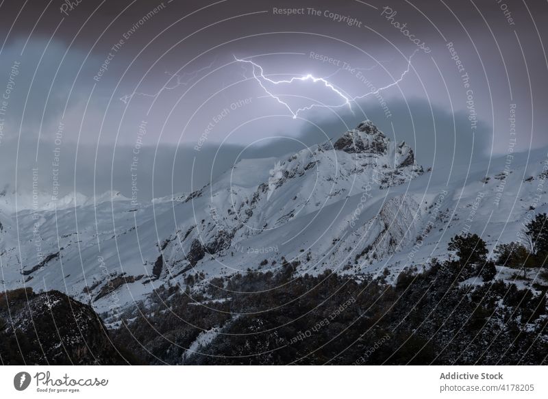 Lightnings in mountainous area in winter range snow cloudy sky dramatic highland landscape scenery cold nature scenic ridge weather season frost idyllic slope