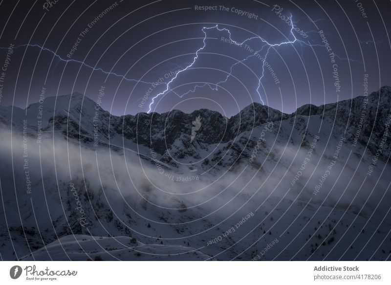 Lightnings in mountainous area in winter range snow cloudy sky dramatic highland landscape scenery cold nature scenic ridge weather season frost idyllic slope