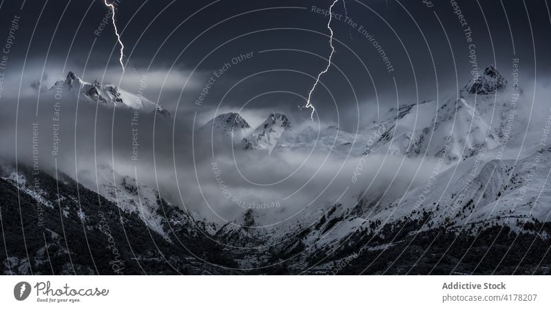 Lightnings in mountainous area in winter range snow cloudy sky dramatic highland landscape scenery cold nature scenic ridge weather season frost idyllic slope