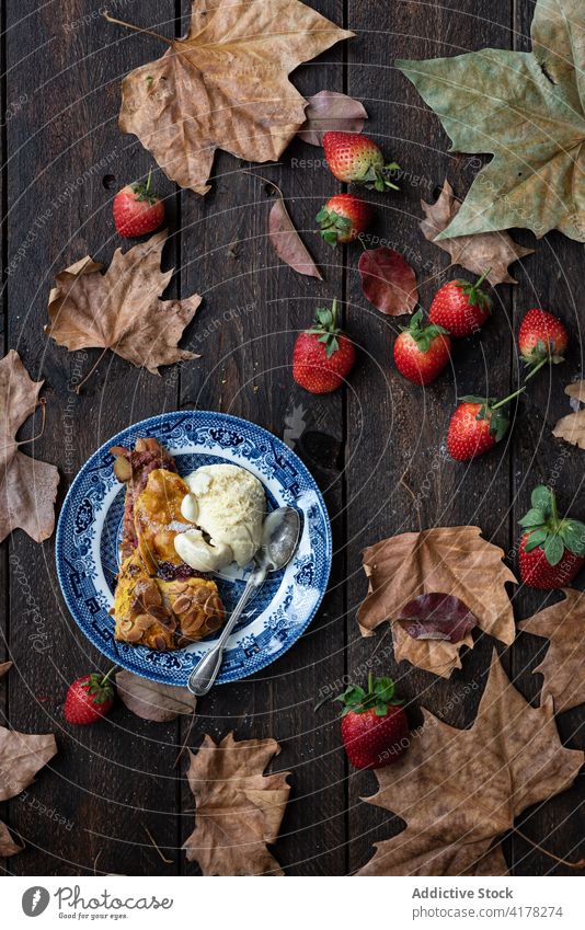 Dessert with ice cream on wooden table dessert sorbet scoop sweet cold delicious strawberry plate yummy dry maple leaf food meal portion tasty treat fresh