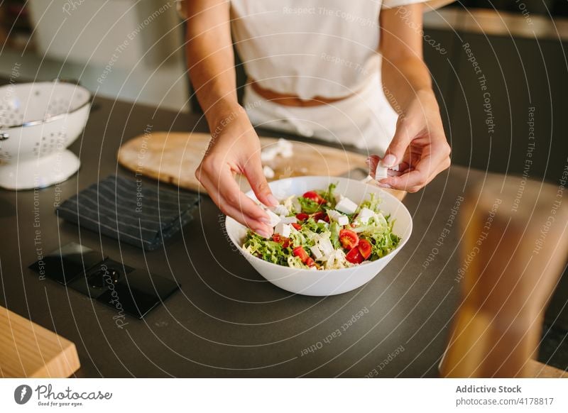 Crop woman cooking vegetable salad at home cheese feta add prepare lunch healthy food female fresh ingredient kitchen organic cuisine vitamin vegetarian meal