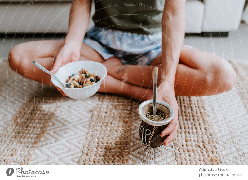 Anonymous woman having healthy breakfast at home healthy food granola eat mate tea detox muesli diet bowl female drink vitamin tasty sit morning meal fresh