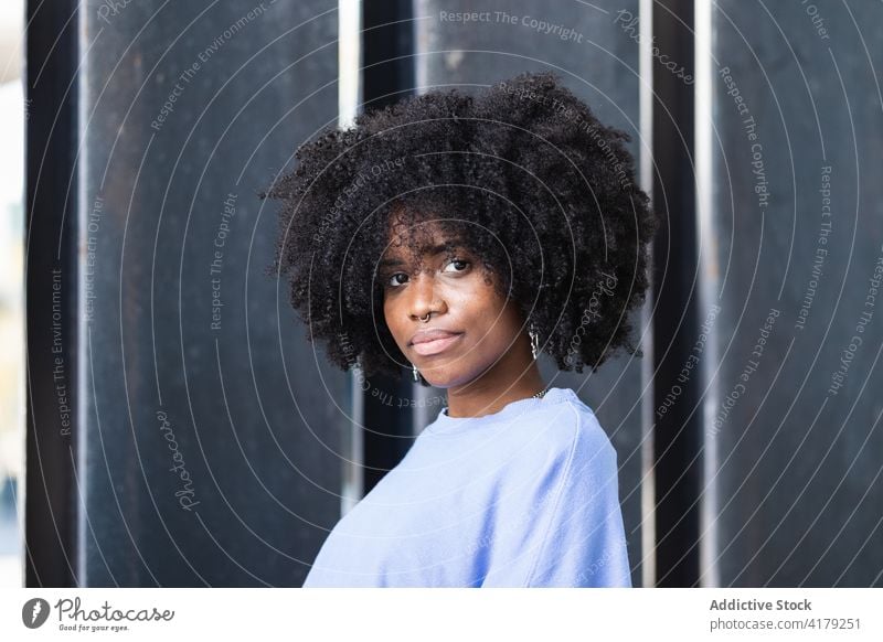 Black woman standing on the street positive afro young african american black ethnic female curly hair hipster lifestyle appearance charismatic millennial