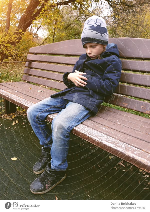 sad boy sitting on bench alone outdoor hopeless remembering thoughtful negative mistake worried despondent adolescent handsome education melancholy teenage