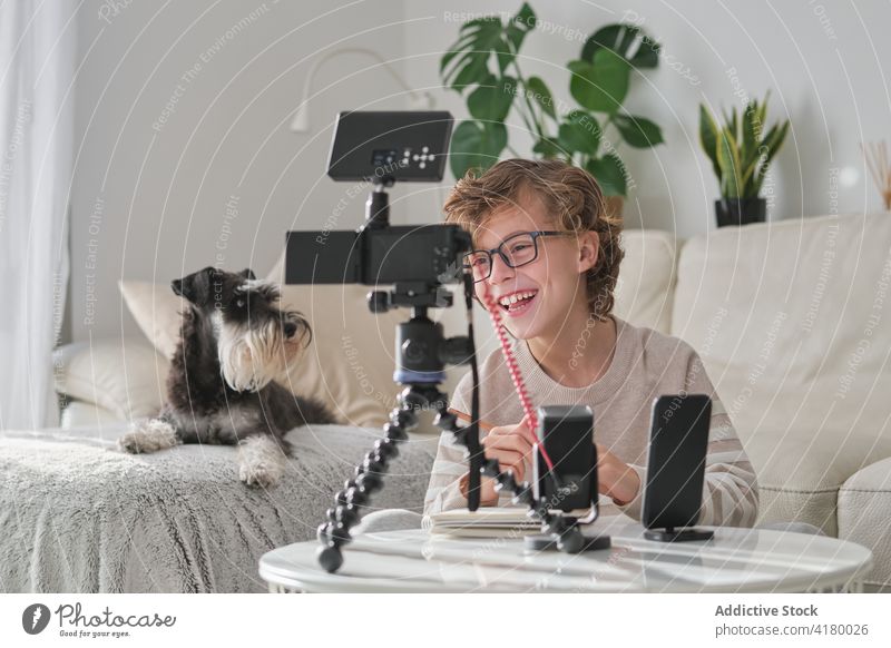 Young Boy Using Tripod at Home filming youtuber cheerful having fun at home kid boy young boy front view preparing technology equipment phone cellphone camera